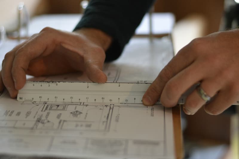 Contractor hands measuring plans