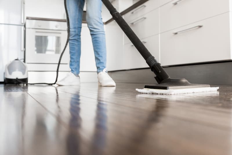 Woman cleaning textured tile floor with steam mop