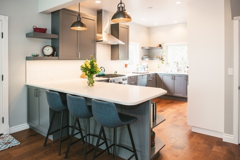 Remodeled kitchen with pendant lights over small countertop eating area