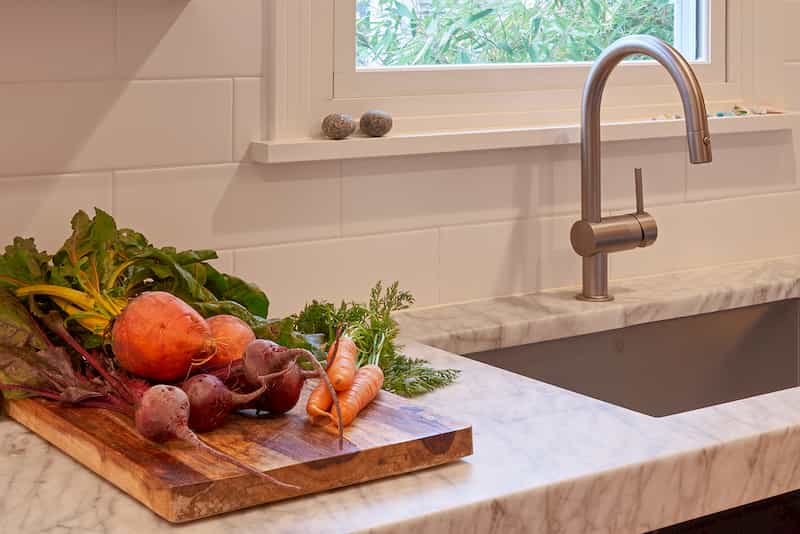 Thick marble countertop with cutting board and vegetables