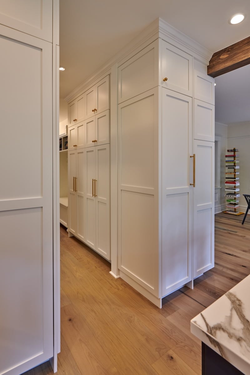 White storage cabinets featuring a brass cabinet door handle