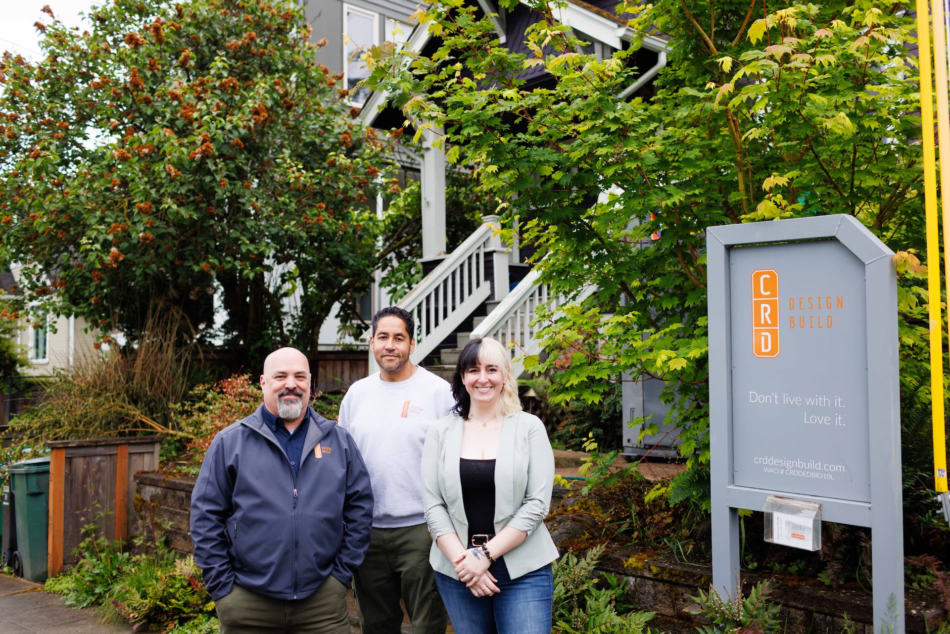 CRD staff in front of a client's home with CRD sign